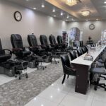 Interior view of a nail salon featuring pedicure chairs and manicure stations with modern decor.