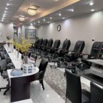 Interior view of Crystal Nail Spa showing nail stations and pedicure chairs arranged in a row.